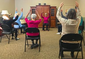 mayflower residents performing chair yoga exercises