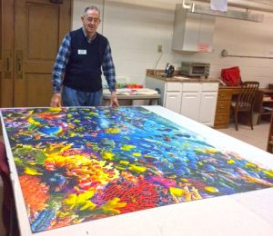 John Noer with completed jigsaw puzzle