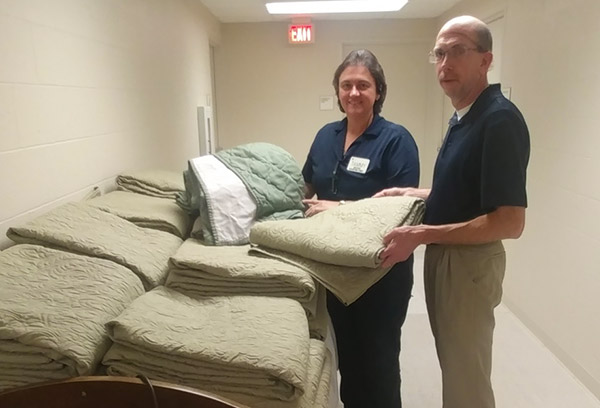 Scott Gruhn and Tammy Long inspecting new bed spreads