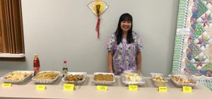Riza Miller with feast she prepared for a Mayflower resident's celebration.
