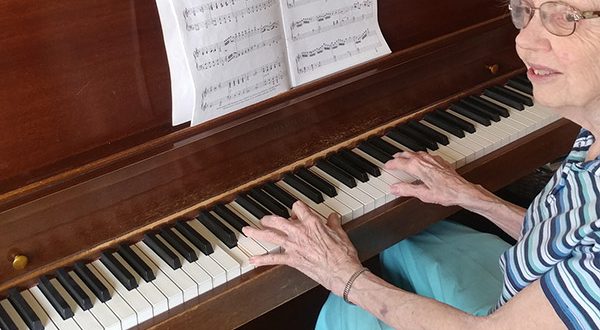 Miss Jeanette Tisdale, retired vocal and music teacher at her piano