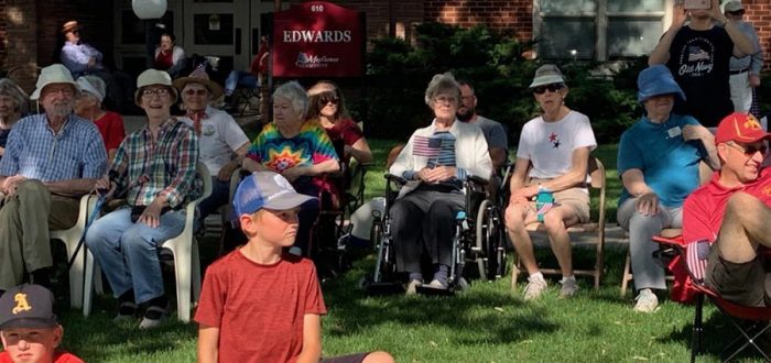 Mayflower residents in the shade, left to right: Dick and Betty Weeks, Jo Entwisle, Mary Long, Addie Hanson, Sue Ahrens, and Jan Peak. In front right is Lance Veldboom, son of resident Norma Veldboom.