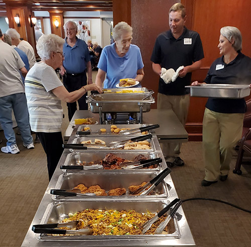 Residents Norma Veldboom (left) and Sandy Beyer await more food from Justin Faircloth and Sharon Gersdorf.