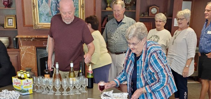 After serving Phyllis Wood, Don Schild is apparently trying to decide if there is enough wine left for him! Behind Don in line are JoAnn and George Britton, Iann Veldhuizen, Suzanne Schwengels, and Darwin Kinne.