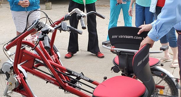 John Brunow demonstrates features on new side-by-side bike to Bonnie Buntz, resident; Jeremy Innis, CNA and Restorative Aide; Casie Vande Stouwe, LPN and Restorative Coordinator; Tracy Woolfork, Activities Assistant; and Chery Nelson, Activities Director.