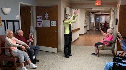 Mayflower’s Stephanie Haworth, RN, PTA, restorative supervisor, leads hallway exercises.