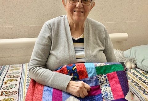 Norma Veldboom with quilt made by Quilt Ladies