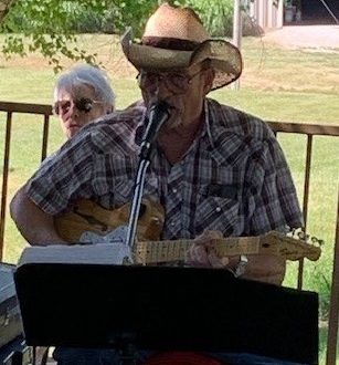 Dennis Perry playing guitar and singing