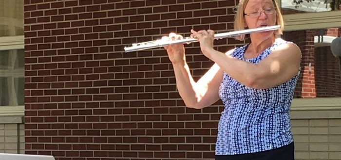 Valerie Wedgeworth playing flute in Health Center Courtyard