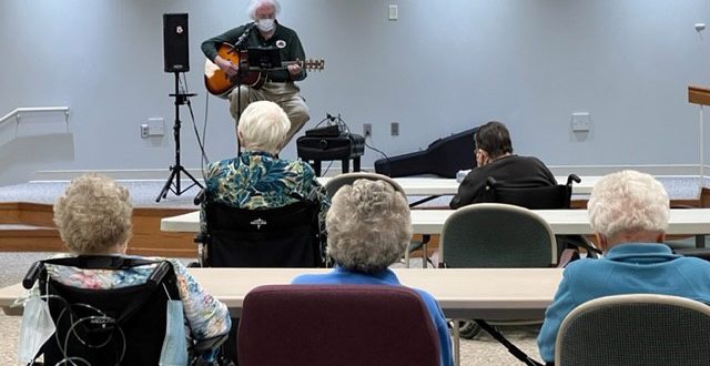 Bill Lawyer playing acoustical guitar for Mayflower residents.