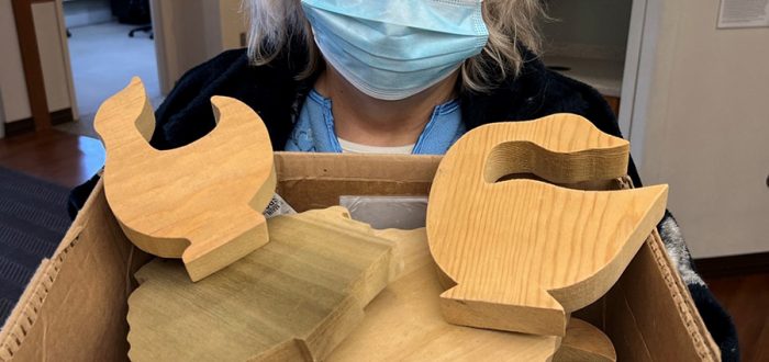 Deanna McGaffrey with a box of donated cut wood shapes