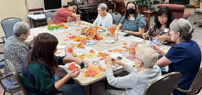 Grinnell College students help make fall leaf craft with Beebe residents